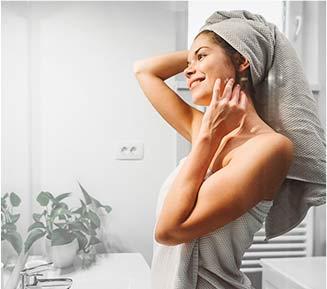 Woman in bathroom with hair wrapped in towel